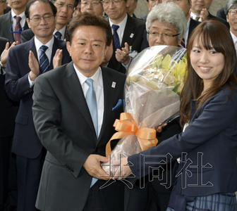 12月18日，高票當選東京都新知事的豬瀨直樹正式到任。圖為豬瀨從政府職員手中接過花束。(共同社)