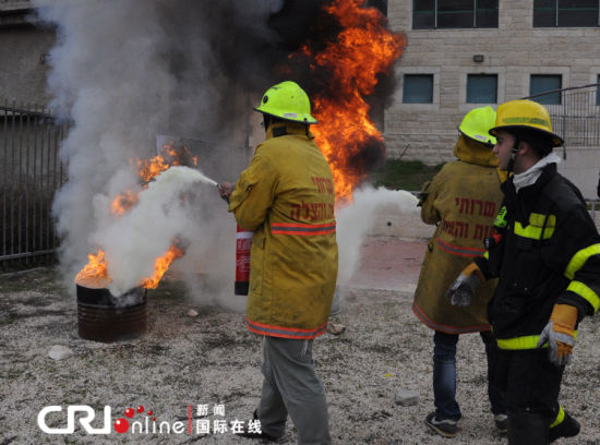兩名志愿者在消防員的指揮下滅火。（攝影：張瑾） 