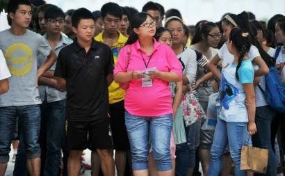 6月7日，雅安天全中學(xué)的呂莎莎老師(中)在考場外等待自己的學(xué)生出來。