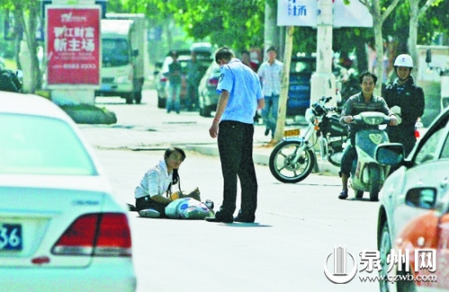 女孩從摩的上摔下，跌坐路中央，恰遇社區(qū)聯(lián)防巡邏人員扶起。