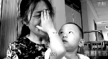 視頻中“小中寶”看到奶奶為他掉眼淚，就伸手為奶奶抹去眼淚。視頻截圖 