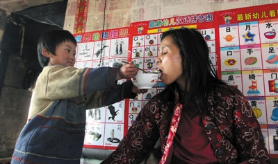 小孫悅為臥床的母親喂飯。