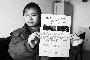 女孩眼含淚水向記者出示自己母親的診斷報告，希望好心人可以幫幫她的母親。　　攝影 李自強