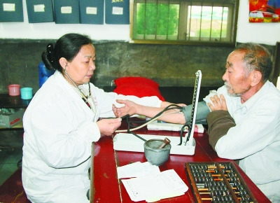 曾玉萍(左)在為患者看病。 喻無(wú)瑕 攝