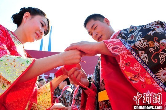 9月1日，一場別開生面的“重溫漢唐風(fēng)”漢式集體婚禮在泉城濟(jì)南舉行，72名新人身著傳統(tǒng)漢服喜結(jié)良緣，并在許愿墻上許下“千年共枕眠，一世永相愛”心愿。圖為新人解纓結(jié)發(fā)。中新社發(fā) 張勇 攝