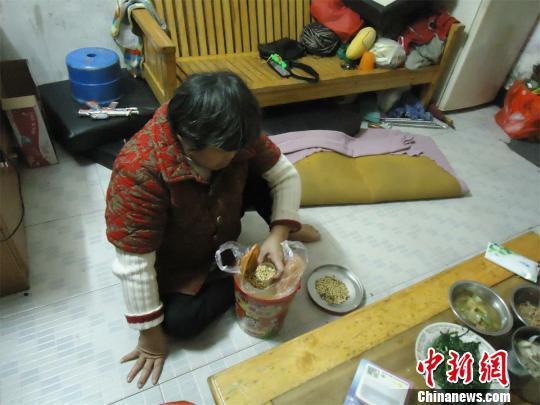 17日下午，56歲小兒麻痹癥患者張紅英爬在地板上找東西。 蘇路程 攝