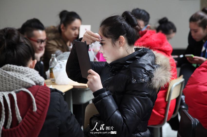 2014年2月17日，山東濱州，藝考候考考生在濱州學院報名點化妝。