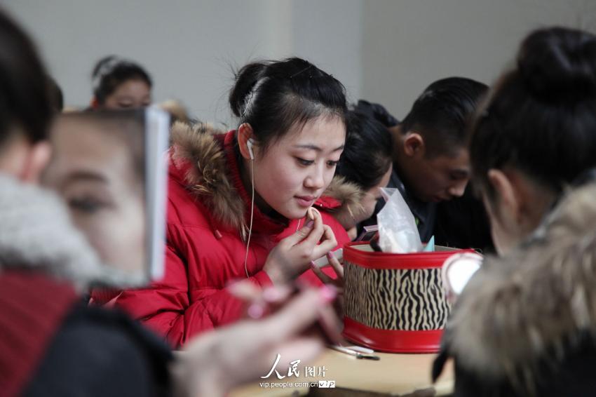 2014年2月17日，山東濱州，藝考候考考生在濱州學(xué)院報(bào)名點(diǎn)化妝。