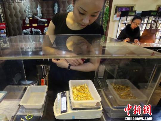 金店工作人員正在稱重?！?jiān)啤z