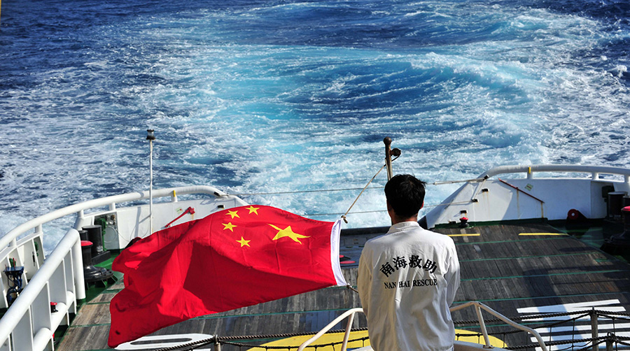 3月18日，水手李國棟在南海救101輪船甲板后部升起國旗。新華社記者 趙穎全攝