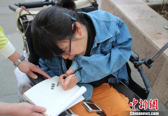 洛洛正在給買(mǎi)書(shū)的顧客簽名。 馮曉林 攝
